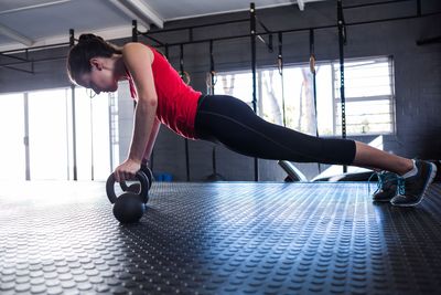 Woman performing kettlebell push-ups at the gym